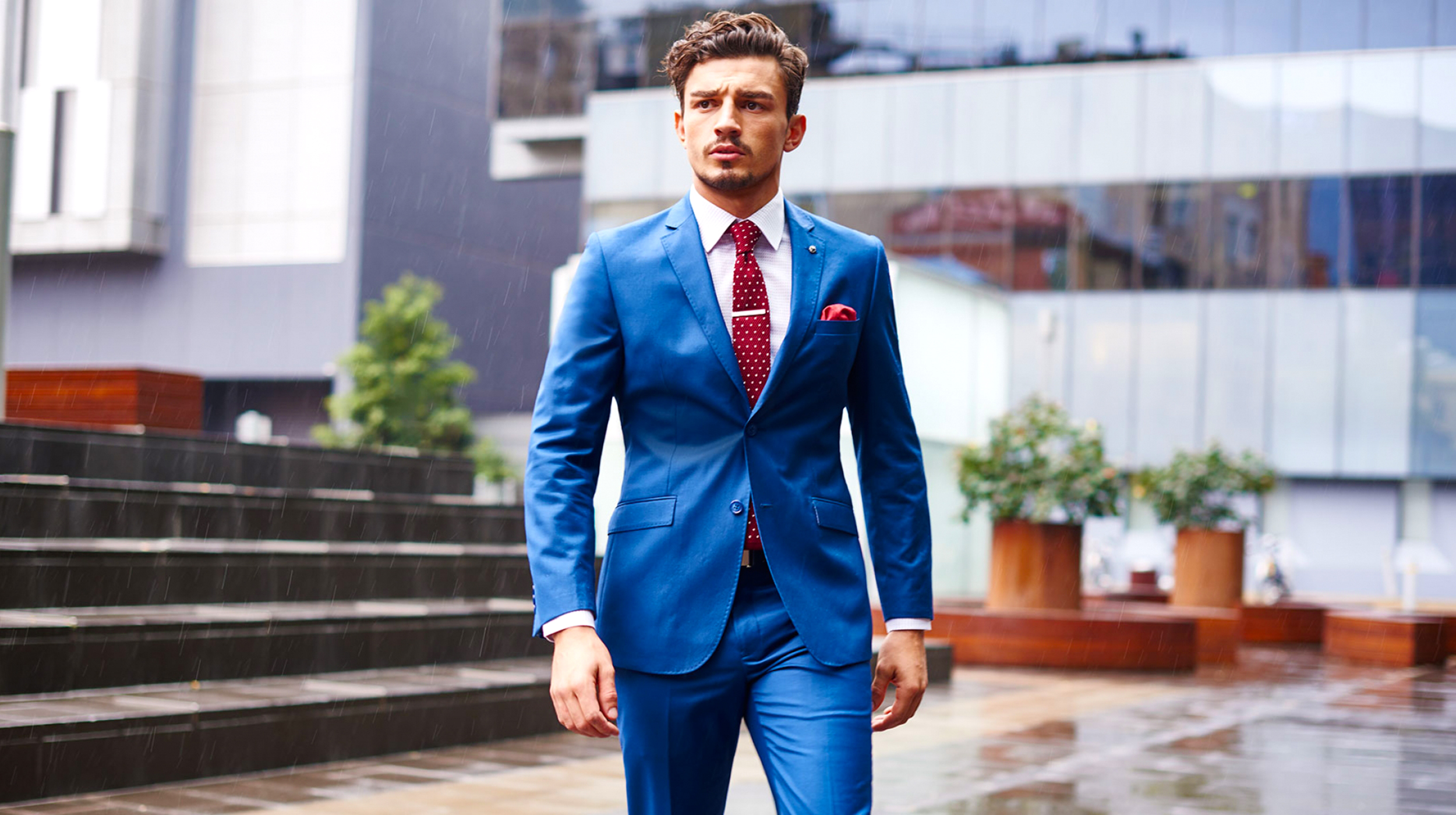 Blue suit matched with a white shirt and a red tie