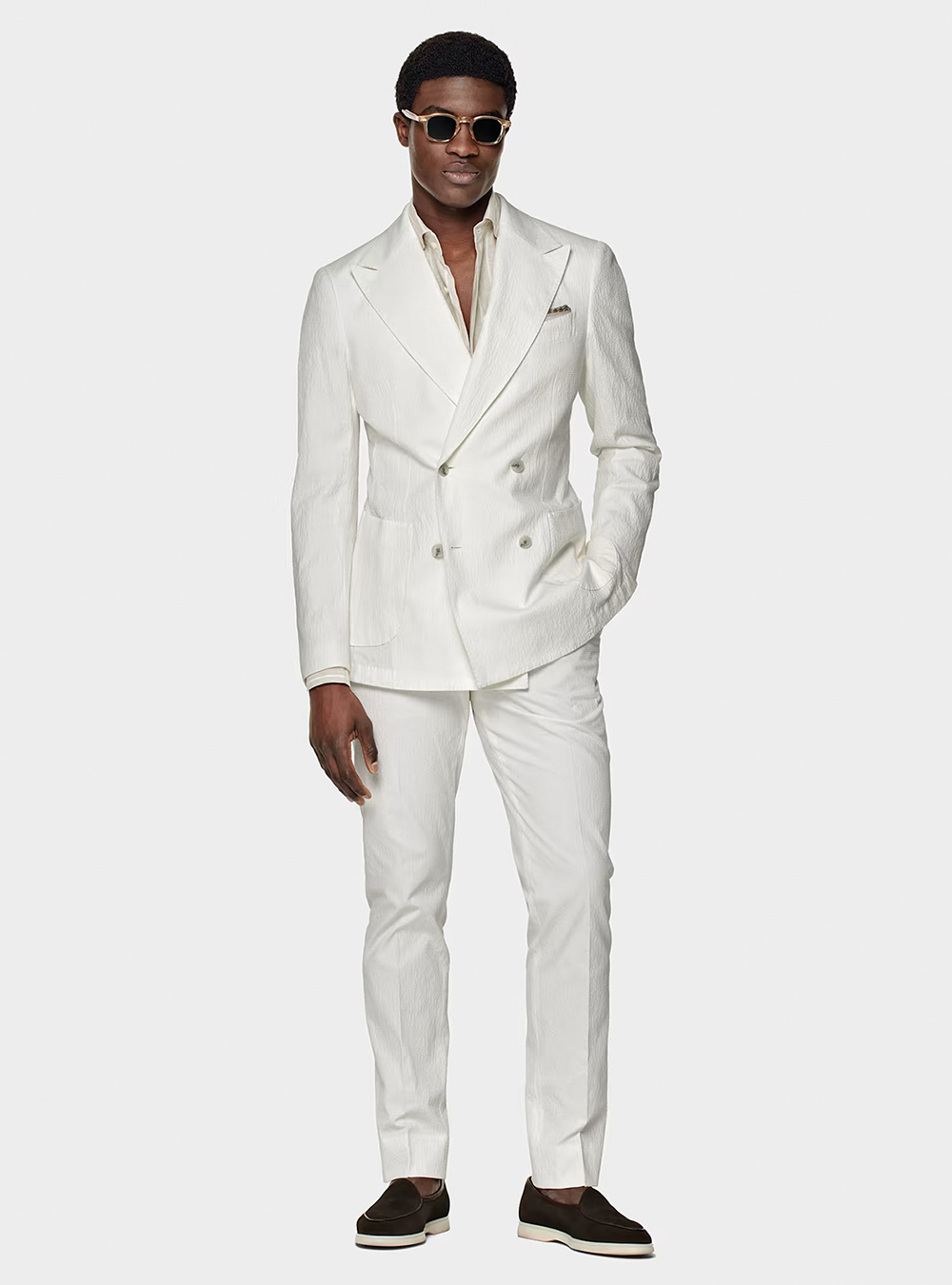 double-breasted white suit, tan shirt, and dark brown loafers
